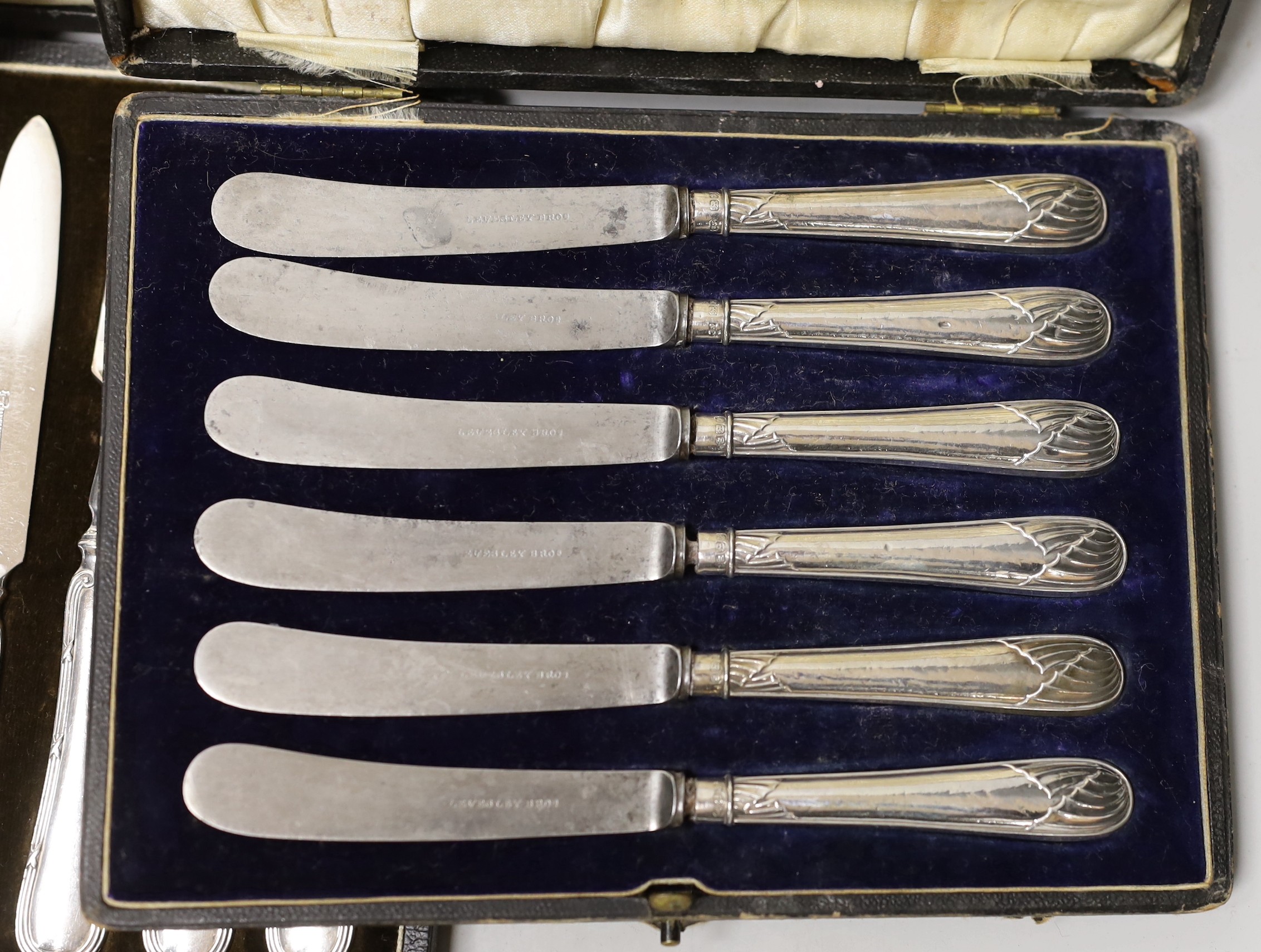 A cased set of six silver coffee spoons, a cased set of six silver-handled dessert knives, a small silver dish and a cased set of plated dessert knives and forks